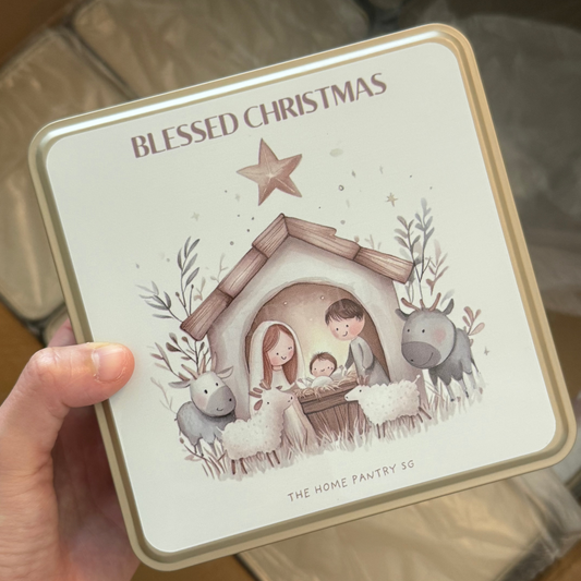 Tin with 'Blessed Christmas' design featuring a nativity scene illustration.